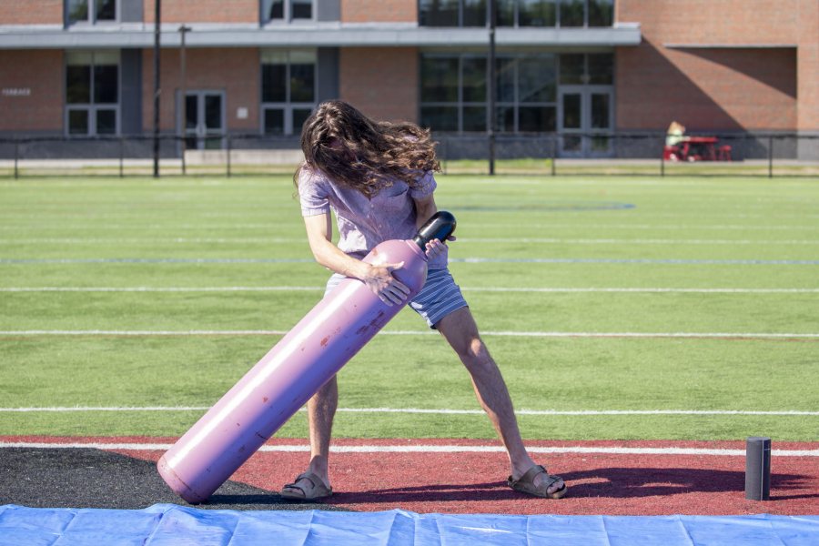 Barker wrestles the helium tank, filled with 200 cubic feet of helium from Maine Oxy, into position. (Phyllis Graber Jensen/Bates College)