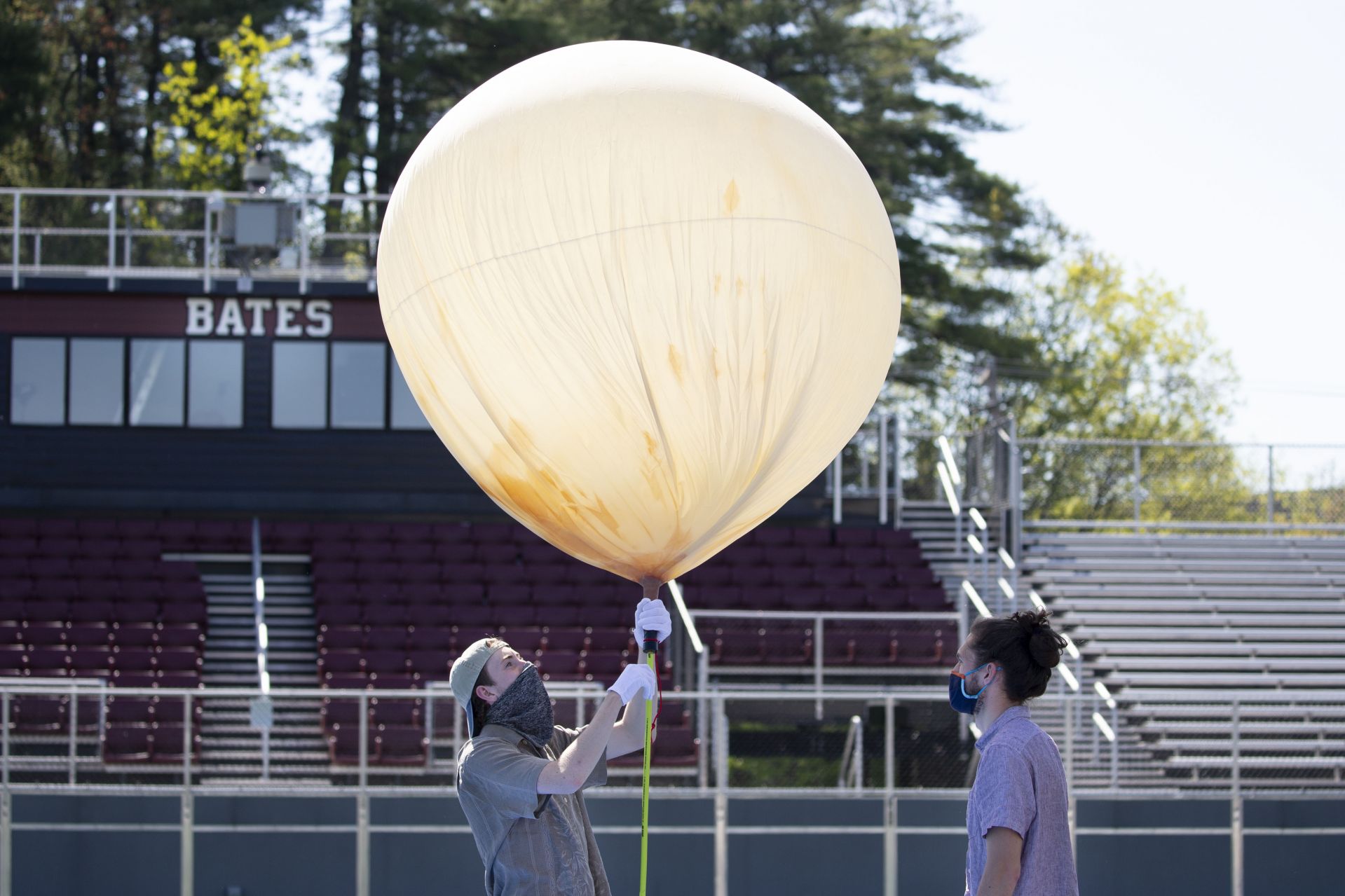 Donahue and Barker evaluate the balloon’s buoyancy after filling it with helium. (Phyllis Graber Jensen/Bates College)