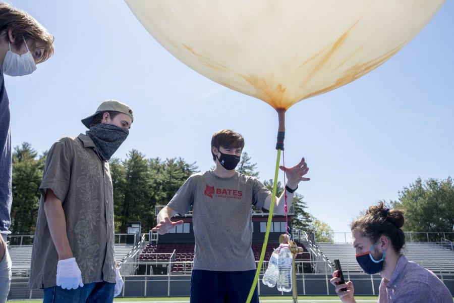 As Alex Brovender '21 of Boxford, Mass., and Donahue watch, Henry Raff '22 of Hailey, Idaho, releases the attached counterweight. At right,Barker reads the positive lift measurement on the brass newton meter and documents the value for post-launch analysis. (Phyllis Graber Jensen/Bates College)