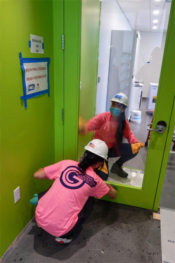 Employees of General Contracting Services of Woburn, Mass., clean a third-floor door. (Doug Hubley/Bates College)