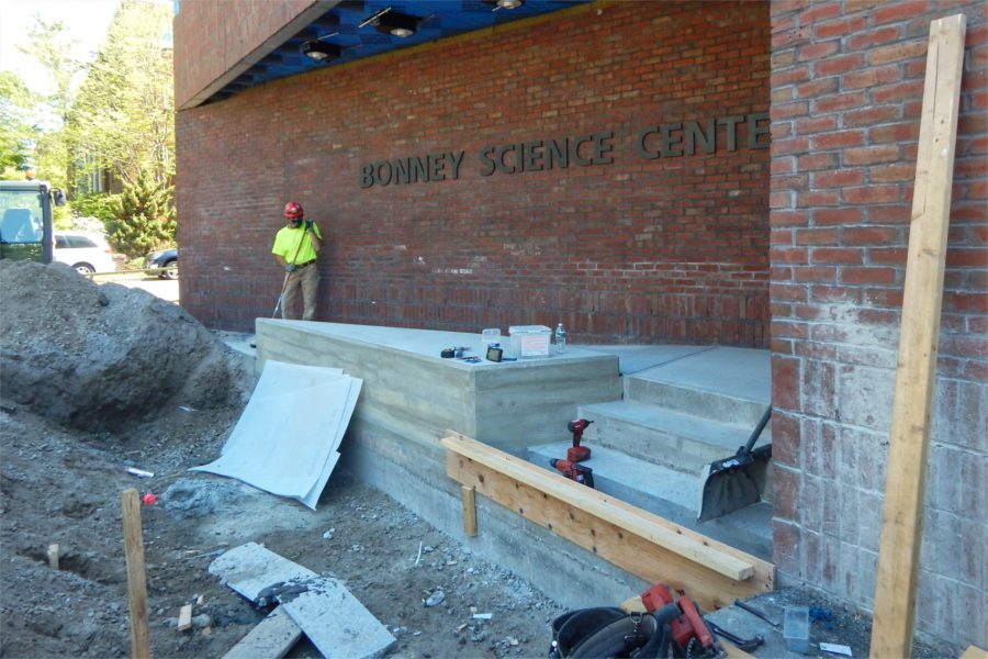 A Consigli Construction employee at work on steps at the Bonney building's Nichols Street entrance. (Doug Hubley/Bates College)