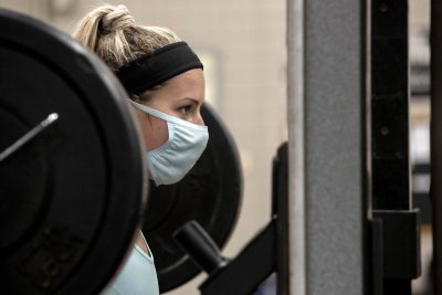 Students work out on equipment moved from the Davis Fitness Center onto tennis court No. 1 in the Merrill Gym on Sept. 30, 2020.Hannah West '21 pressing 135 lbs, and squatting/streteching