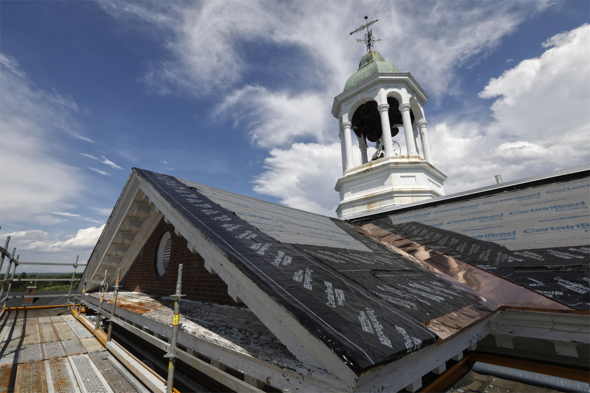 With the century-old slate removed from Hathorn's roof, new weather barrier and copper flashing have been placed in preparation for the new slate in this June 30 image. (Theophil Syslo/Bates College)