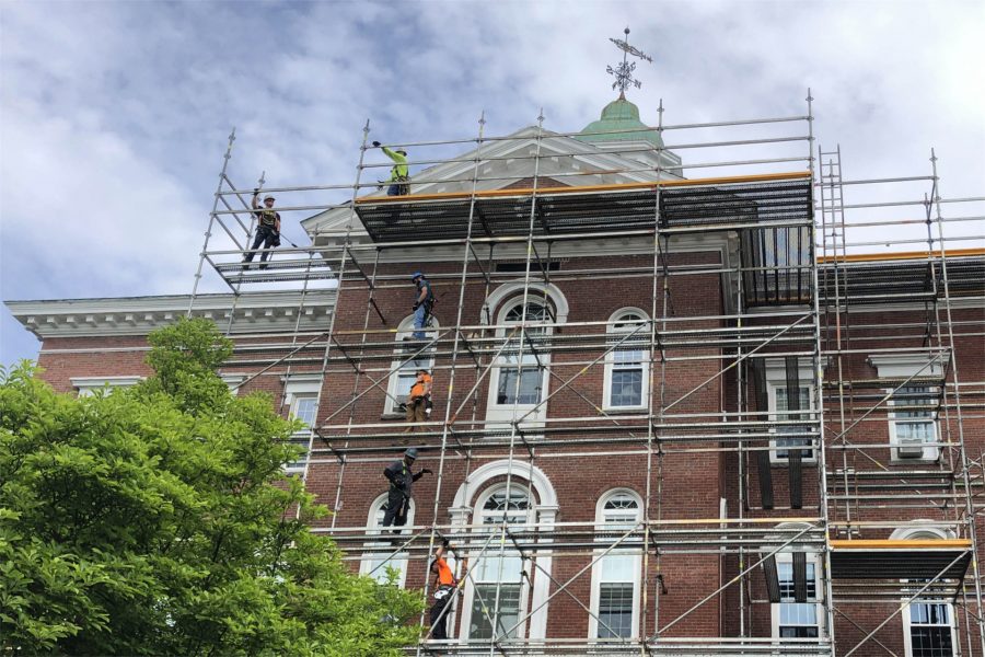 Workers for G&E Roofing are shown on on June 3 on  staging erected around Hathorn Hall in connection with the replacement of the building's roof. (Jay Burns/Bates College)