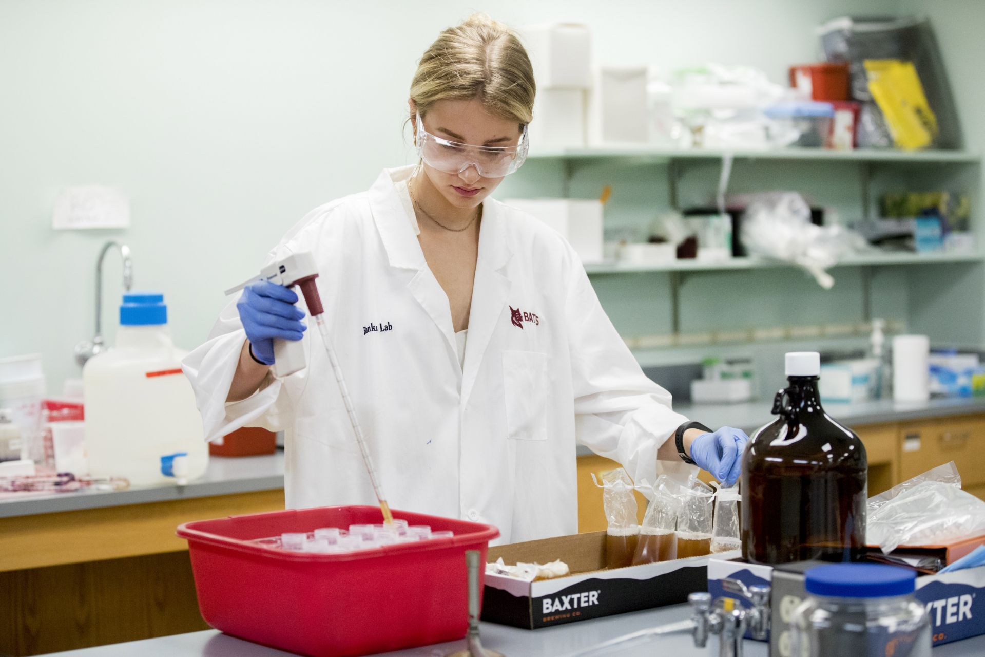 Emily Tamkin '22, a biology major from Lafayette, Calif., is doing a summer '21 purposeful work internship tin brewing science, partnering with the Baxter Brewing Co. in Lewiston, where she's studying the number of battering compounds that exist in beer throughout the brewing process. She is working under the supervision of Merritt Waldron, Baxter's quality control manager, and Assistant Professor of Biology Lori Banks.  Emily picks up samples from Baxter's plant at 130 Mill Street in Lewiston and takes them to Carnegie Science where, in Dr. Bank's lab, she conducts a chemical analysis of them. The compounds hit your taste buds, and your brain understands that they are bitter, she says.