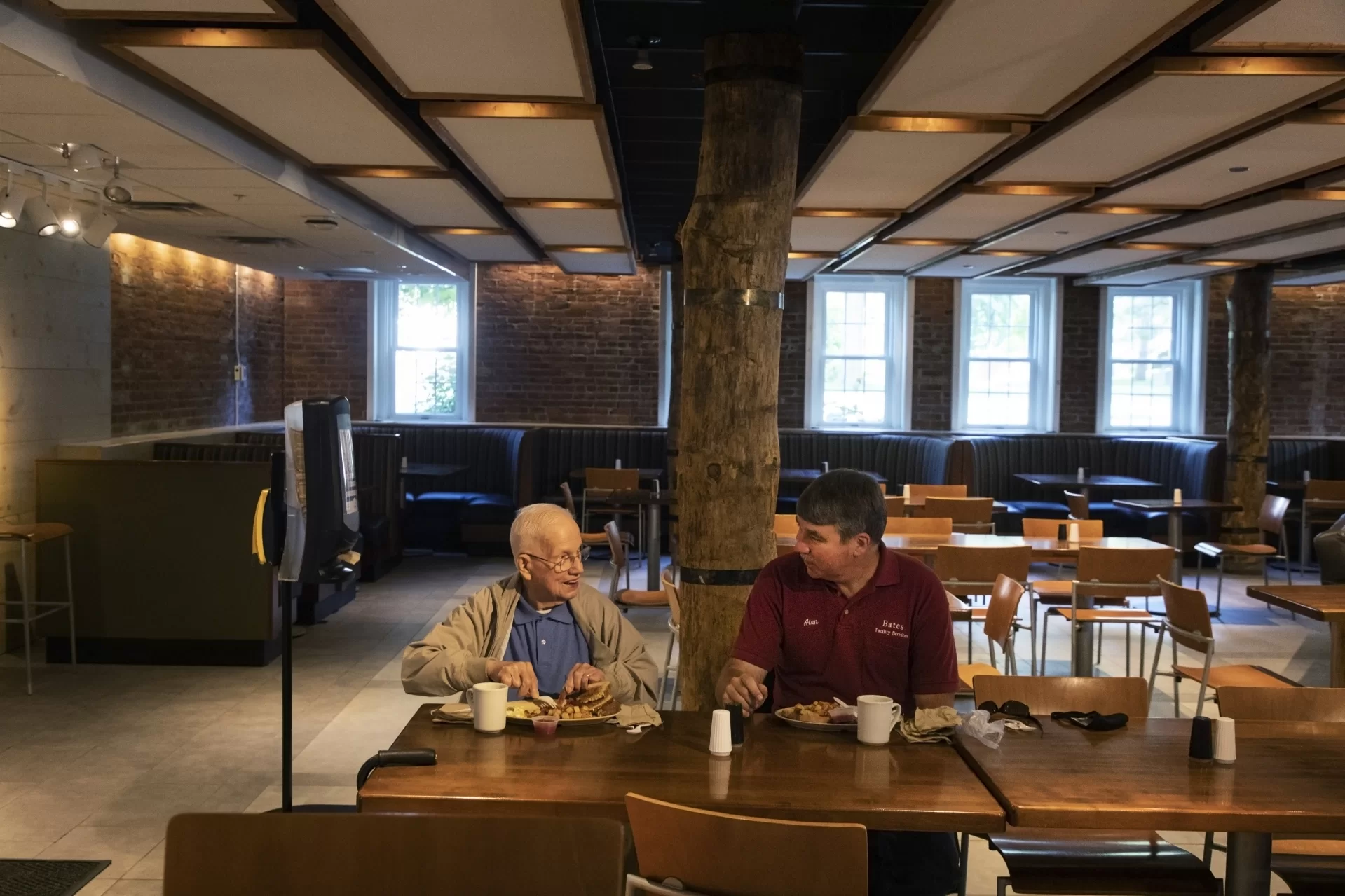 Ralph Sylvester '50, age 97, and Alan Kelley of Bates Facility Services renew a morning routine, having breakfast together in the Bobcat Den, which reopened Aug. 17 after being closed since March 20, 2020, due to the pandemic. (Theophil Syslo/Bates College)