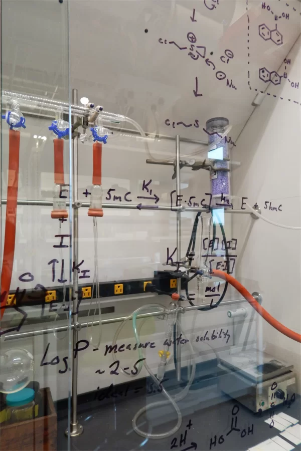 The glass front of a fume hood in the Bonney Center lab of Andrew Kennedy, assistant professor of chemistry and biochemistry, is the ideal place to make notes for a lab process. (Doug Hubley/Bates College)