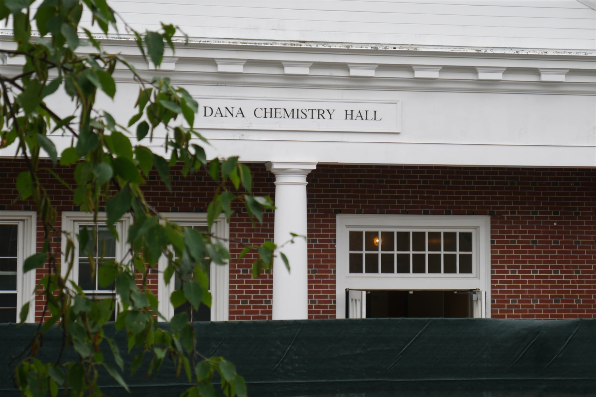 Seen from Alumni Walk, Dana Chem is partially veiled by a green site fence. (Doug Hubley/Bates College)