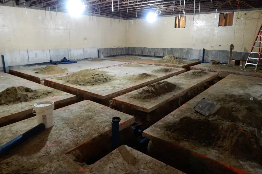 Room 119, now with 100 percent less raked seating. The blue pipes in the trenches will carry discarded chemicals away for proper disposal. (Doug Hubley/Bates College)