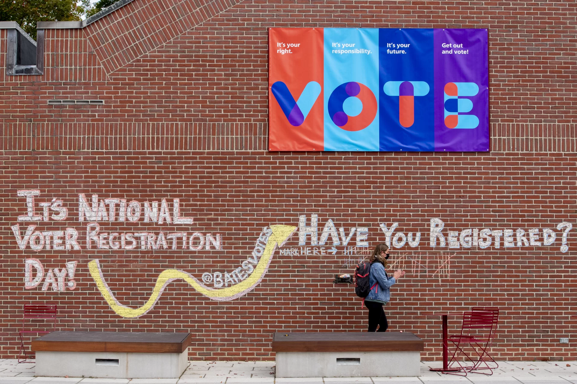 A student on Ladd Plaza wipes chalk from her hands after adding to the voter-registration tally on the library wall on National Voter Registration Day.

The hope and energy of students “is so uplifting,” says Peggy Rotundo, director of policy and strategic initiatives for the Harward Center for Community Partnerships. “They provide light and hope.”