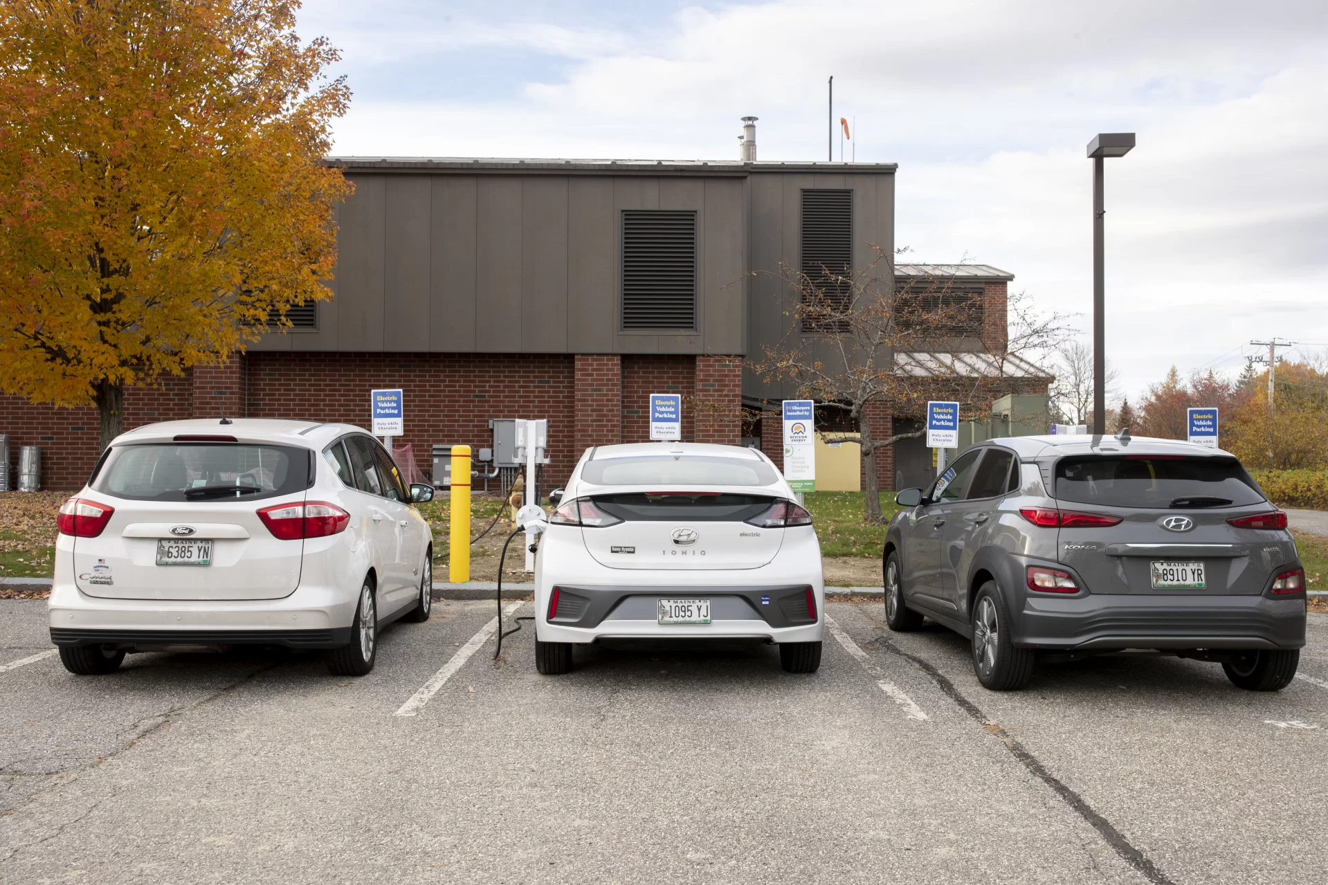 Ecorep Tamsin Stringer ’22 of Bloomington, Ind., poses at the new electric charger stations behind Underhill in the Merrill Gym parking lot.
“Underhill Electric Vehicle Chargers Project “
Bates has installed other EV chargers in the past. This project will be different for three primary reasons. First, we have already received a grant from CMP for the make-ready infrastructure portion of the project, which has historically been the bulk of the expenses for EV charger installations. Secondly, this project will include installing level 2 chargers for the first time at Bates, which will allow for monetary collections for charging, tiered charging for different kinds of customers, and incentivize to move one’s car once it's fully charged. Finally, this project allows for future EV charger installations in the same location for much lower cost, because the make-ready infrastructure for more EV chargers will be easily accessible.
