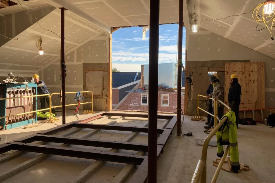 Workers watch as a crane floats an air-handler component (center) toward the attic of Dana Chemistry Hall. (Jacob Kendall/Bates College)