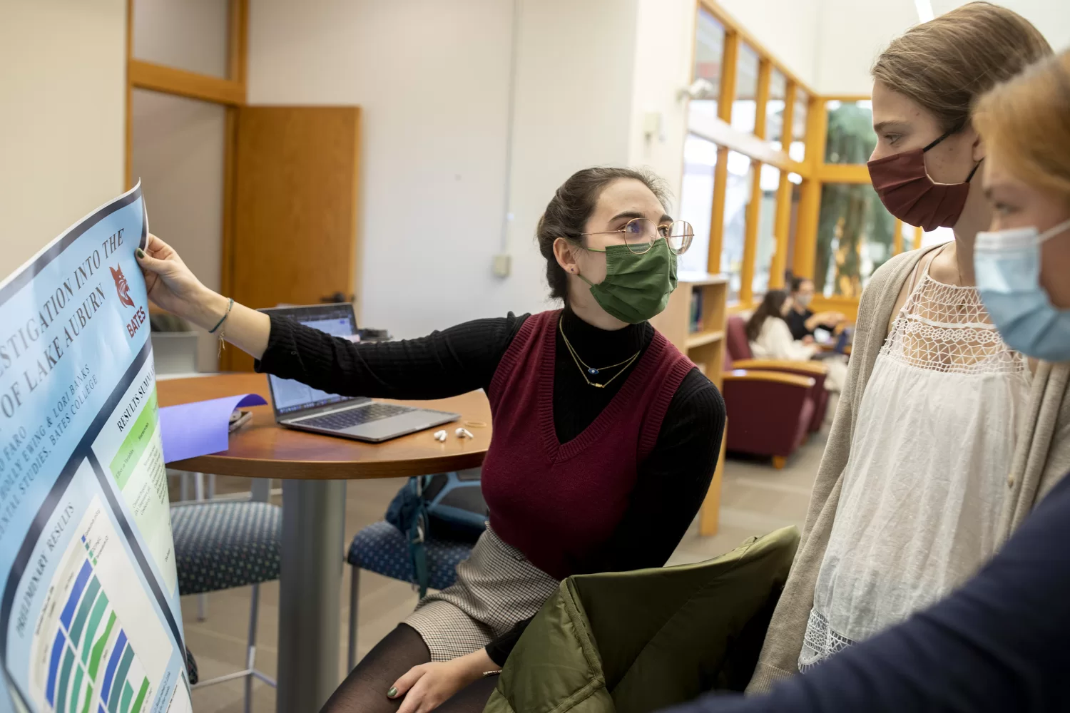 Don't forget to stretch for senior thesis — and finals!

Ashley Koman '22 of Burlington, Mass., a double major in history and sociology, demonstrates the art of stretching during this morning's Early Bird Thesis Cafe in Ladd Library's Writing and Language Center.

The cafe provided an opportunity to study in the company of other thesis writers, or "to enjoy warm tea or coffee and a pastry...or Flamin' Hot Cheetos," according to Bridget Fulletron, lecturer in humanities and acting director of writing, who organized the event, part of a series of senior thesis cafes that were held throughout the semester. The last one, the Afternoon Pickup Cafe, is today from 4 to 6 p.m.

"Thesis writing is such an intellectual process. We spend so much time in our brains," Fullerton said. "We forget we have bodies."

Identifications: 

Oliver Barrera (in orange shirt), Latin American studies and politics, double major. Studying with Margaret Flynn, a politics major;

Ashley Koman, a double major in history and sociology, studying under Steven Pinker poster;

Writing tutor and fellow Martha Coleman ’23, a French and American studies double major, is “working on email and other work for Gateway Community Services Maine, a local non-profit (in plaid shirt);

Isabel Fenton ’23, sitting and talking with Bridget Fullerton, is a politics major, from Silver Spring, Md., in white sweater

Ben Schmandt ’22 (in black hoodie), an ARC tutor in chemistry and biology;

Christina Wang ’22 of Woodcliff, N.J., is a double major in English and Politics, is wearing a black hat and on her heavily labeled laptop;

Chloe Lo Faro ’22, is an environmental studies major who is showing her poster to her friends Milly Detels ’22, a math and physics major in garnet mask, and Saskia Wong-Smith ’22 a double major in psychology and Chinese.