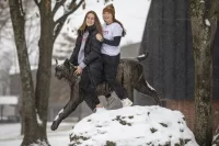 Anna Cote ’25 of Auburn, Maine, and Emily Gianunzio ’22 of Darien, Conn., pose on and by the Bates Bobcat.They are field hockey teammates this year; last year, Gianunzio, on a one-year leave from Bates because of the pandemic, coached Cote when the latter was a senior at St. Dom’s.