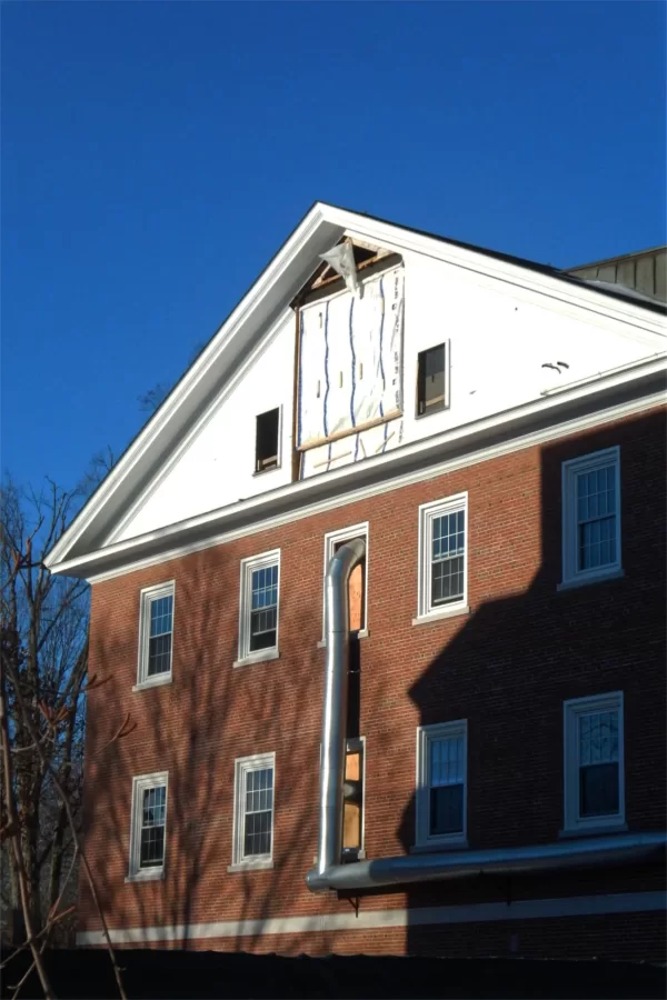 A heavy plastic sheet covers the large opening in Dana Chem's east gable through which a large air-handling machine was loaded in November. The silver pipe is feeding warm air from a portable heater into the building. (Doug Hubley/Bates College)