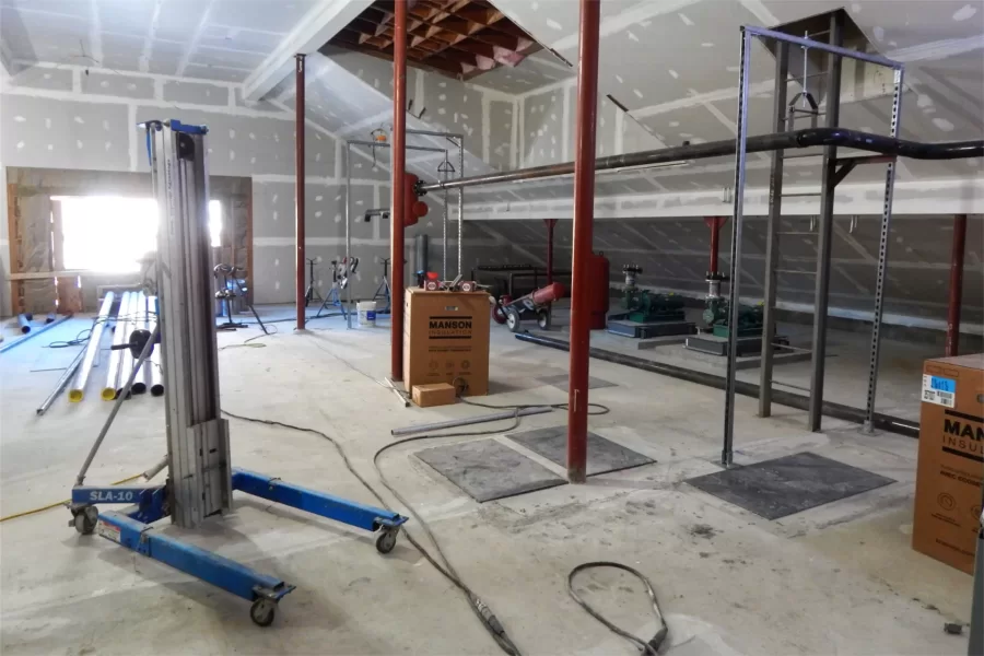 Dana Chem’s attic, facing Parker Hall. Behind the photographer is the elevator and the new HVAC machine, which takes up a third or half of the attic. Additional air-handling equipment and other utilities — note the two pumps at center right — will occupy the space shown. (Doug Hubley/Bates College)