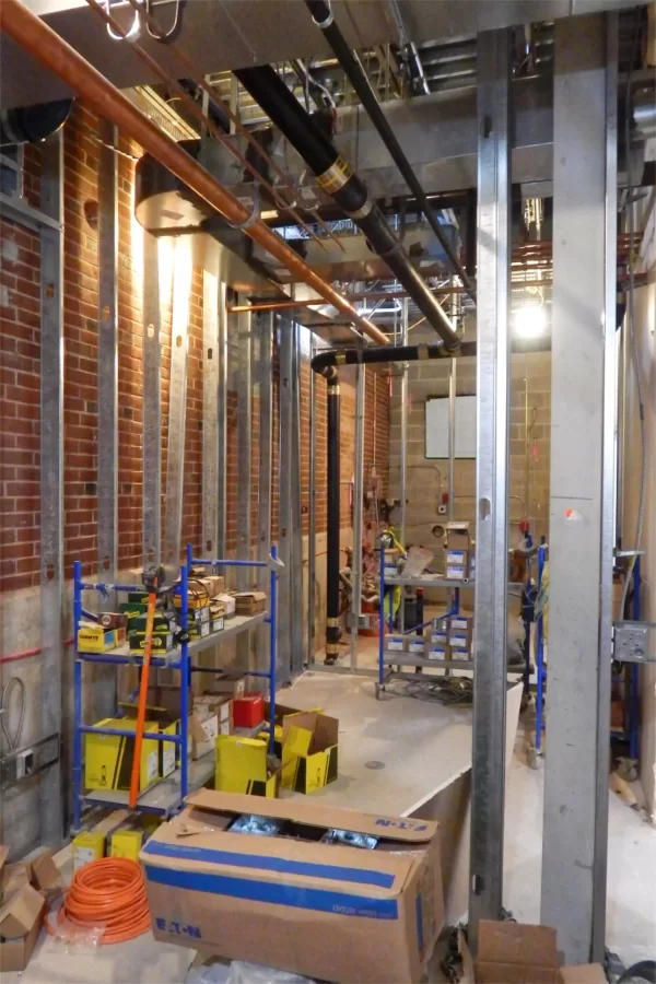 The first-floor area nearest the camera will house a kitchenette, mailboxes, and a copier. Plumbing will occupy the space at rear. (Doug Hubley/Bates College)