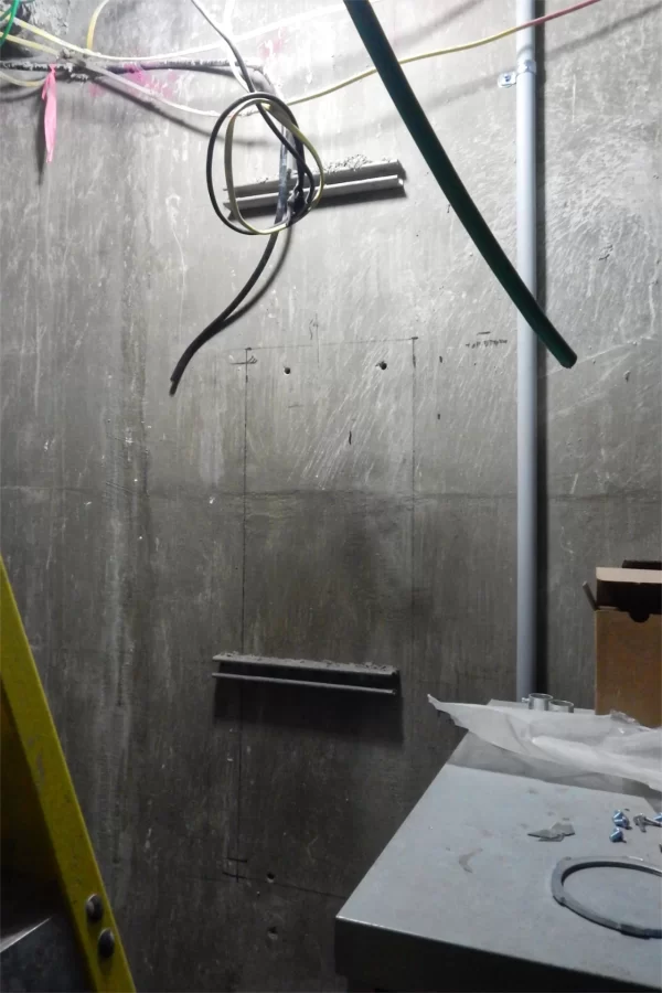 The pencil outline surrounding the lower bracket shows the location of Dana Hall’s original electrical panel, in the basement. Where the old panel was the size of a kitchen cabinet, the new one is bigger than a refrigerator. (Doug Hubley/Bates College)