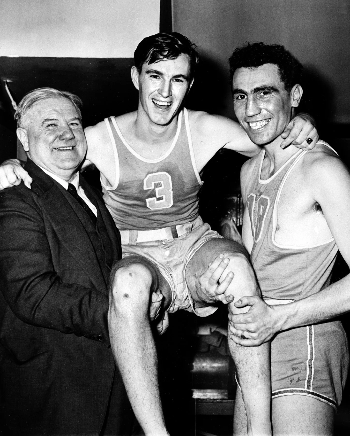 ** FILE ** Rhode Island center Ernie Calverley, center, is carried by   Coach Frank Keaney, left, and Al Palmieri, right, for victory ride in the dressing room at Madison Square Garden in New York during the  NIT, in this March 14, 1946 file photo after a victory over Bowling Green. Calverley, who starred as a basketball player for the University of Rhode Island and later coached the Rams to the NCAA tournament, died Monday, Oct. 20, 2003 in Providence, R.I. after a brief illness. He was 79. (AP Photo,File)