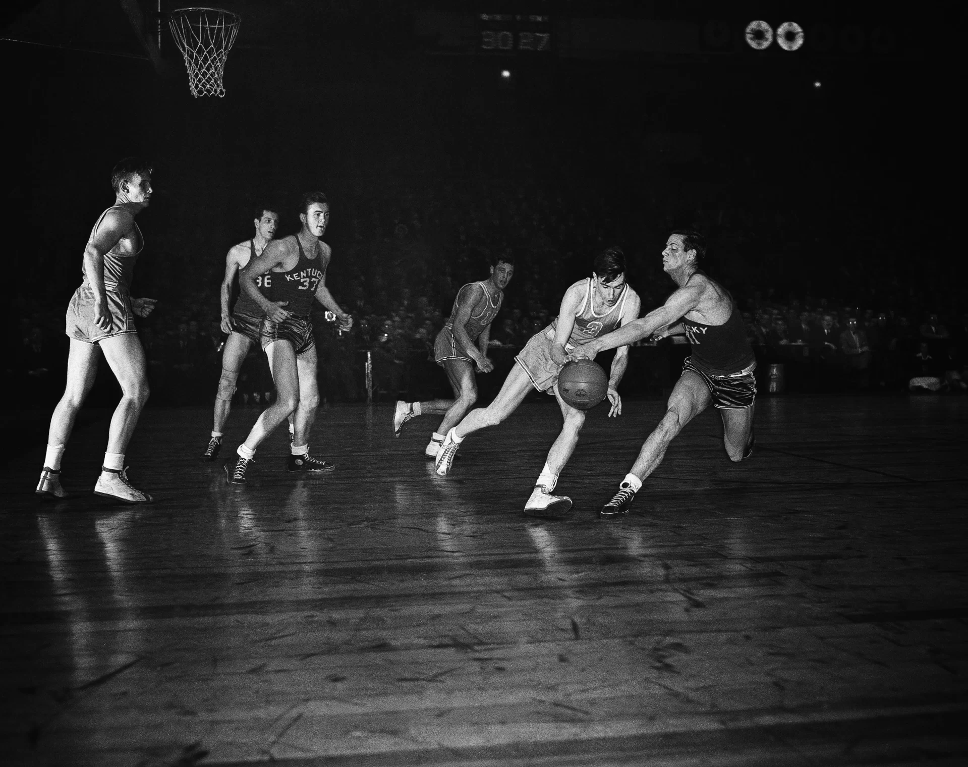Ernie Calverley (3), Rhode Island State center, and Wallace Jones, right, Kentucky center, go into high gear attempting to take possession of a free ball in the second period of the final game of NIT at Madison Square Garden in New York, March 21, 1946. Calverley was named MVP in the tournament but his team lost the final game to Kentucky, 46-45. (AP Photo/Matty Zimmerman)