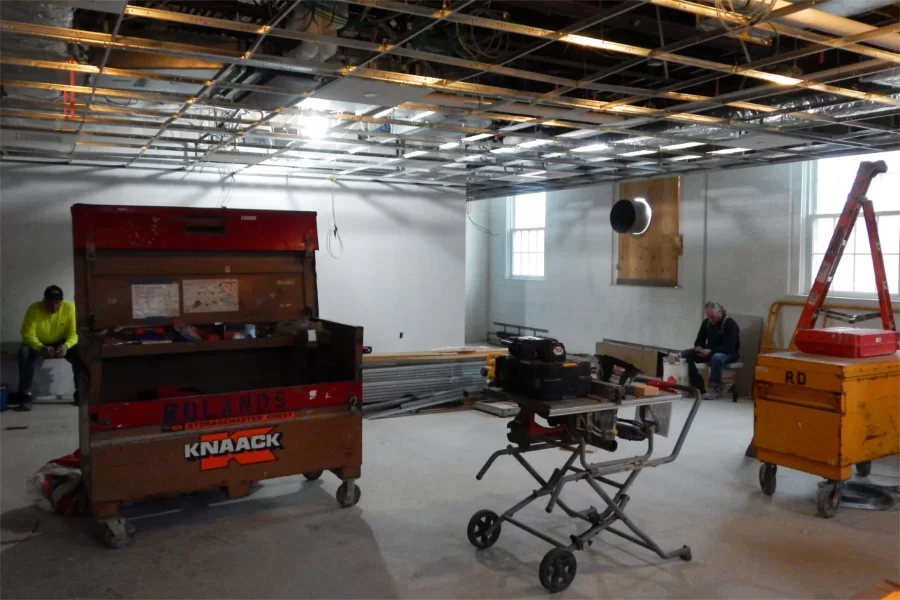 Ceiling grids have been hung in much of Dana Hall. In this second-floor classroom, taking a break are workers for Roland's Drywall. (Doug Hubley/Bates College)