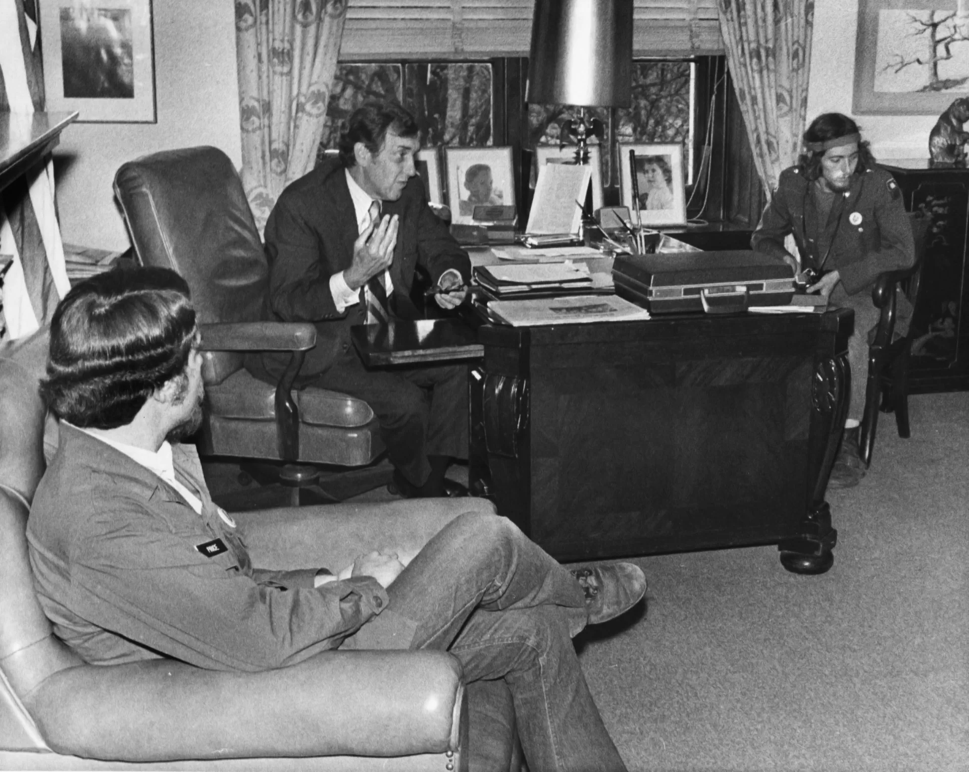 In a quintessential pose and place, Sen. Edmund Muskie '36 sits behind his desk and engages in discussion with Vietnam veterans from Maine on April 22, 1971. (Muskie Archives and Special Collections Library)