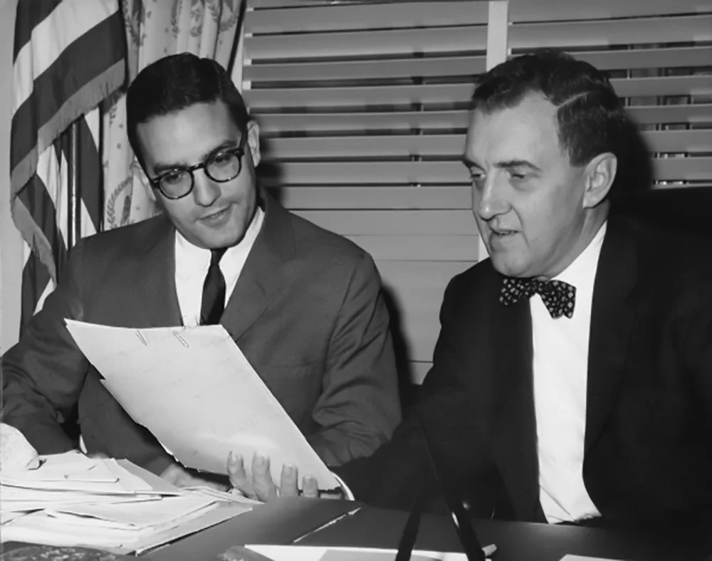 Future senator George Mitchell sits with Sen. Edmund Muskie '36, presumably behind Muskie's Senate office desk, in this undated photograph. Mitchell served as Muskie's executive assistant from 1962 to 1965 and took over Muskie seat in the Senate — and his famous desk — in 1980. (U.S. Senate Historical Office)