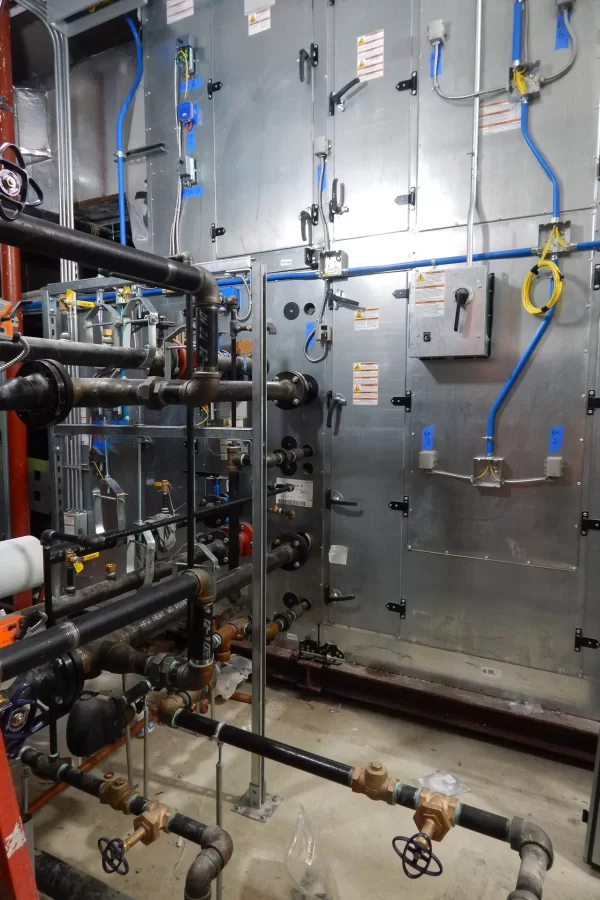 Steam, control, and electrical connections to the main HVAC unit, in Dana's attic. (Doug Hubley/Bates College)