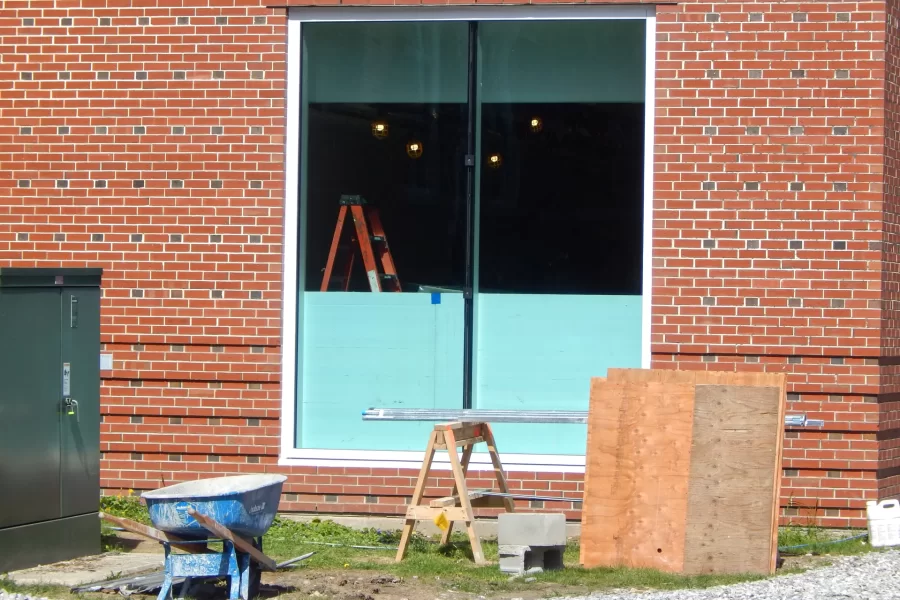 A new window in Dana Hall’s new ground-floor lounge, adjacent to Alumni Walk. The window will provide generous views toward Commons and Garcelon Field. The blue plastic foam is protecting the glass while construction is ongoing. (Doug Hubley/Bates College)