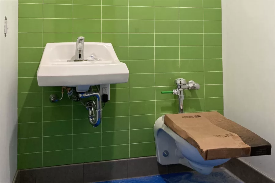New fixtures in a Dana Hall restroom. The cardboard is to remind construction crewmembers to use the portable facilities outside. (Doug Hubley/Bates College)