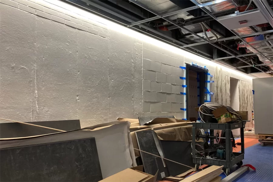 As shown in Dana Hall’s first-floor lobby, the architects at Payette selected "wash" lighting fixtures to accentuate textural contrasts among wall sections of different vintages. Note the fume hood at right awaiting installation. (Doug Hubley/Bates College)