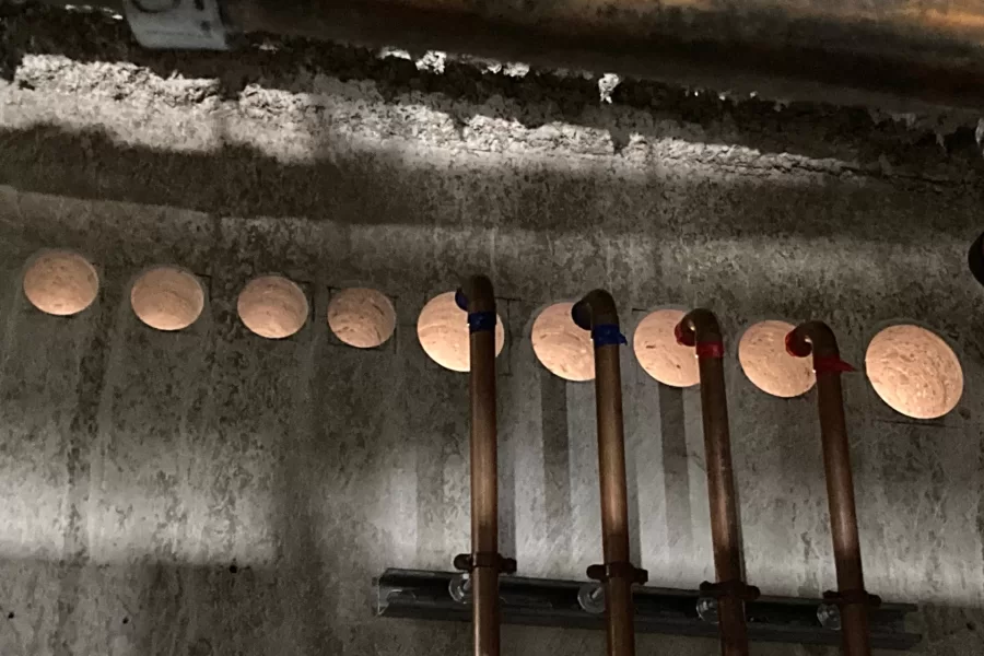 Pipes linking an outdoor chiller to Dana Hall's HVAC system will come in through these new holes in the foundation. (Doug Hubley/Bates College)