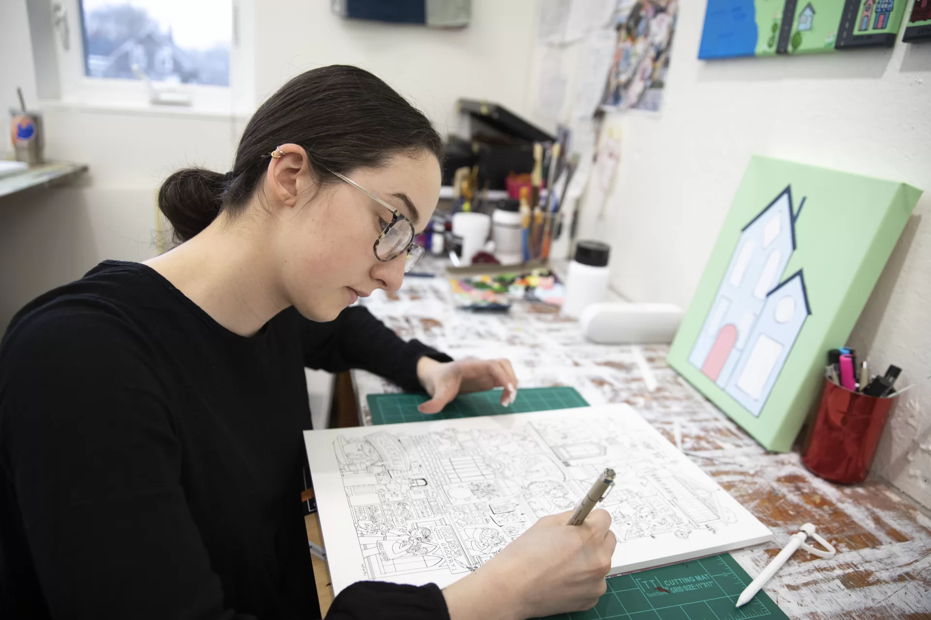 Art and visual culture majors with a studio concentration work in their first-floor Olin Arts Concert Hall studios in preparation for the Annual Senior Exhibition that will open in April at the Bates College Museum of Art.

Emily Graumann ’22 (in gray sweater) of Salem, a double major in AVC and English, is producing a thesis in hand-drawn animation.

Ollie Penner  ’22 (purple shirt) of Pasadena, Calif,, is a double major in AVC and American Studies, whose thesis uses photography and Photoshop.

Kathy Boehm ’22 (black sweater) of Denver, Colo.,  is a double major in AVC and American studies, who’s designing town with  drawings and mixed media.

Mary Richardson ’22 (black tank top) of Blue Hill, Maine, is a double major in AVC and psychology and exploring themes of growing up and bodily image. She’s using mixed media and colored pen.