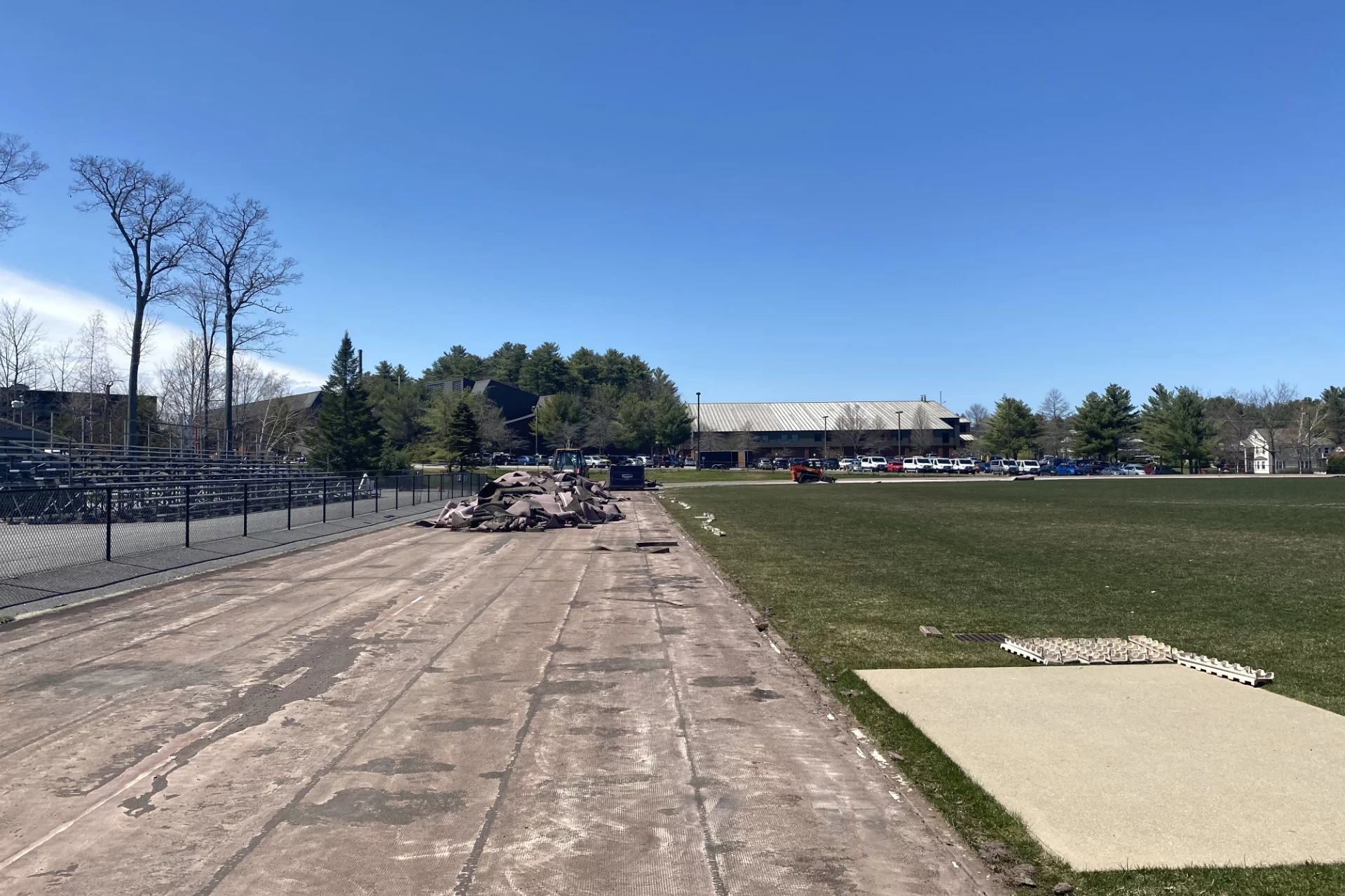 In this May 2 image of the Russell Street track complex, the heap at center left is the old Mondo track surface, scraped up and awaiting disposal. (Paul Farnsworth/Bates College)