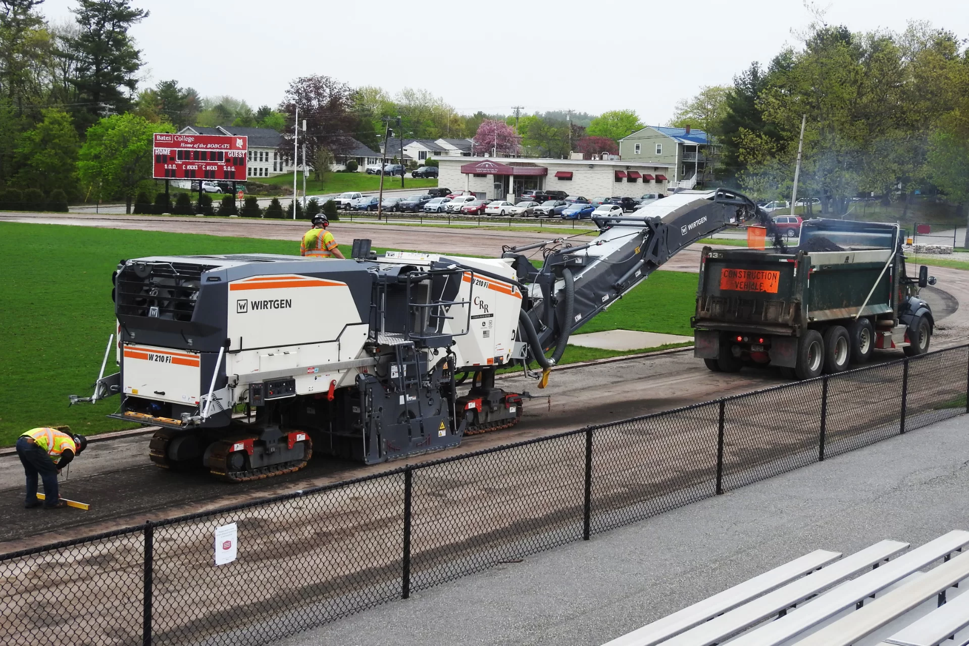 A milling machine removes the old 1.5-inch "wear layer" of asphalt, comprised of 9.5mm aggregate, at the Russell Street track at Bates College on May 16, 2022, in preparation for laying down a new layer of asphalt, upon which a new track surface, Mondo Super-X 720, will be applied. Coastal Road Repair handled the milling machine. (Jay Burns/Bates College)