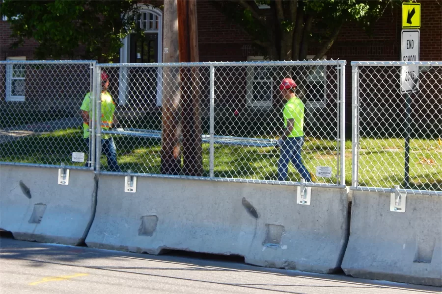 Setting up a construction site fence at Chase Hall. (Doug Hubley/Bates College)