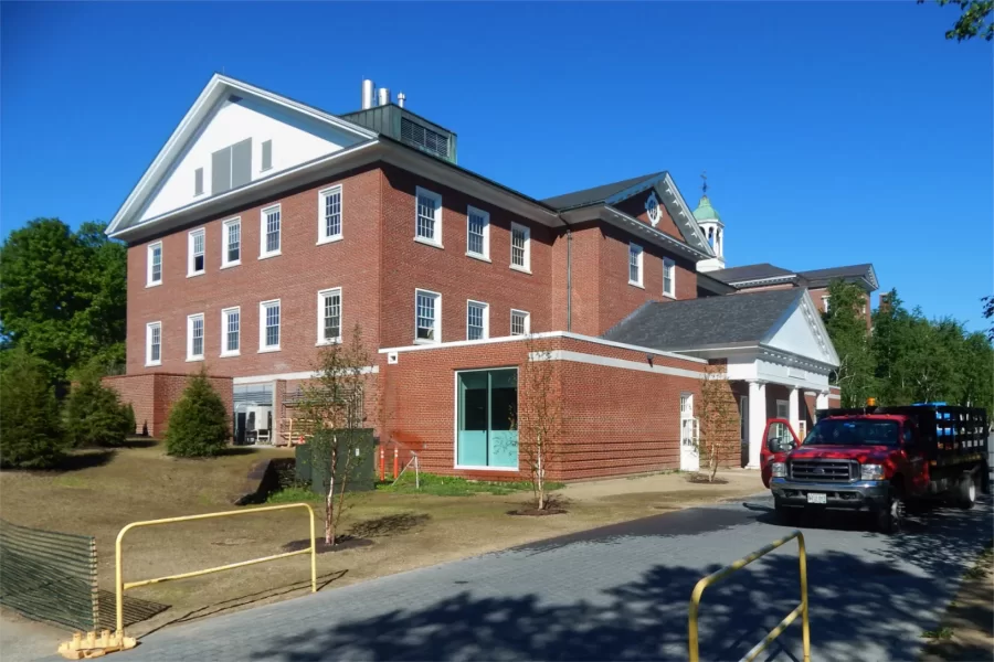 The full-size, view-blocking construction site fence around Dana Hall has been replaced with a lightweight plastic barrier, seen at left, to protect the newly seeded grass. (Doug Hubley/Bates College)