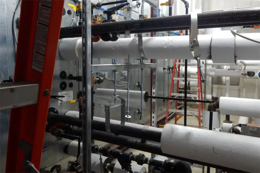 Sprouting a mind-bending array of steam, water, and control connections, Dana Hall’s main air handler was among systems recently test-started. (Doug Hubley/Bates College)