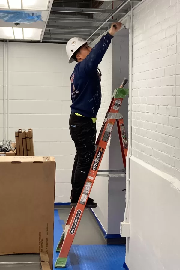 A painter at work in a Dana hallway. (Doug Hubley/Bates College)