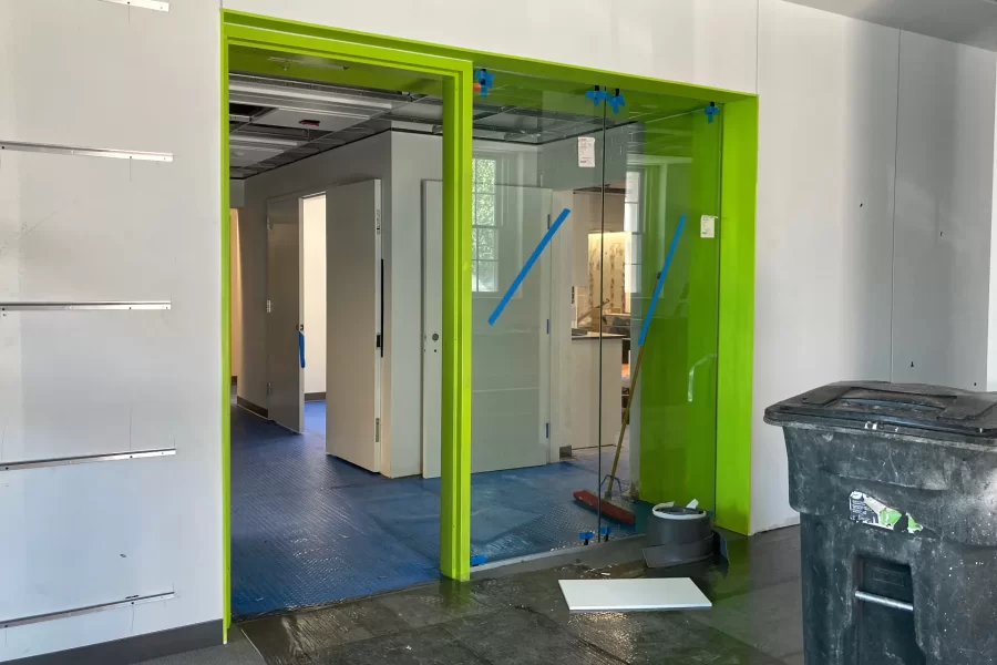 A doorway from Dana Hall’s first-floor lobby, at Alumni Walk, into the main part of the building. The use of plenty of glass and the bright green accent paint are two visual motifs that Dana shares with the Bonney Science Center. (Doug Hubley/Bates College)