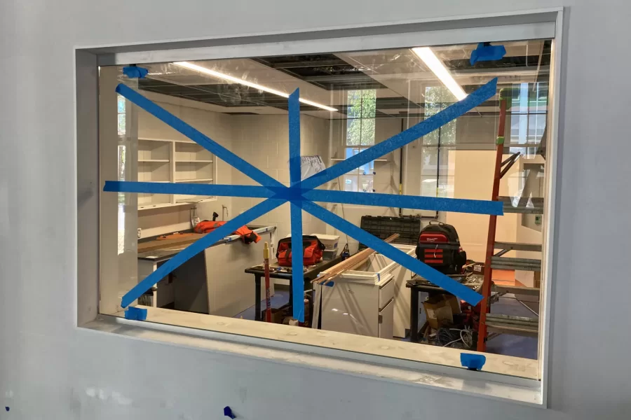This interior window affords views into the first-floor chemistry preparation area in Dana Hall. The tape, of course, is to call attention to the glass while work in the building continues. (Doug Hubley/Bates College)