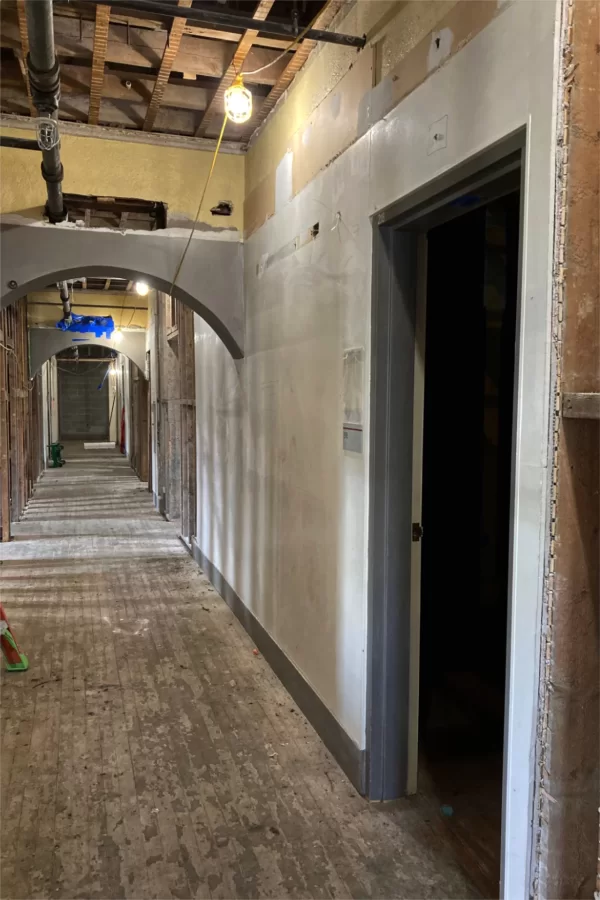 A second-floor corridor in Chase, substantially gutted. The layered-up wallboard here and farther down the way will soon be removed. This area has been offices in recent decades, but students were quartered here from the 1940s through the ’60s. (Doug Hubley/Bates College)