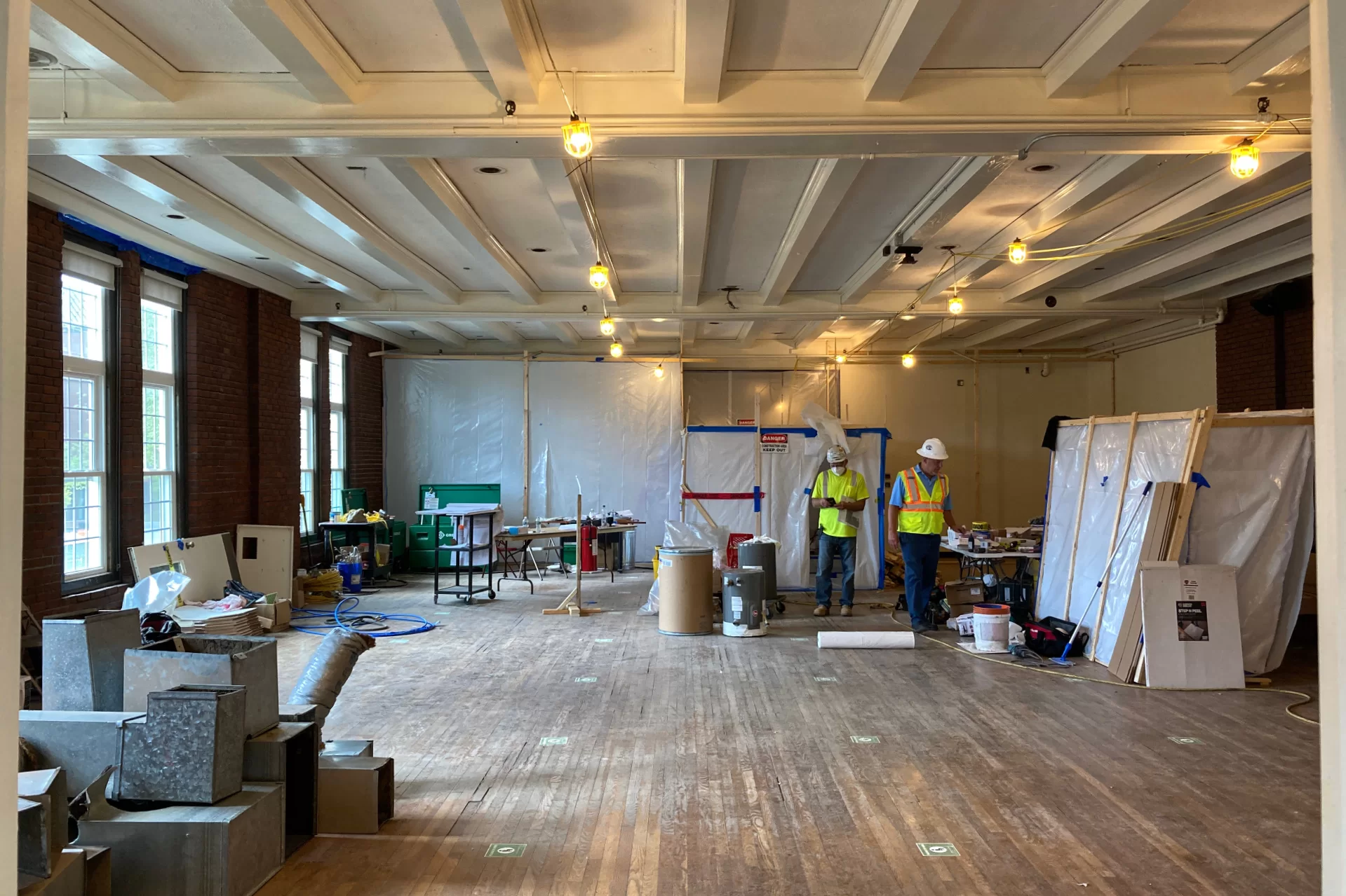 Chase Lounge will get a makeover in the coming months, but at the moment it provides office and supply space for workers on the Chase Hall renovation. Behind the poly sheeting, hazardous waste abatement is underway.  (Doug Hubley/Bates College)
