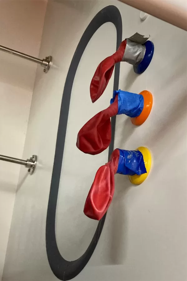 Balloons are taped onto nozzles in a fume hood to help detect any leaks in the hood's gas, air, and vacuum supplies. (Doug Hubley/Bates College)
