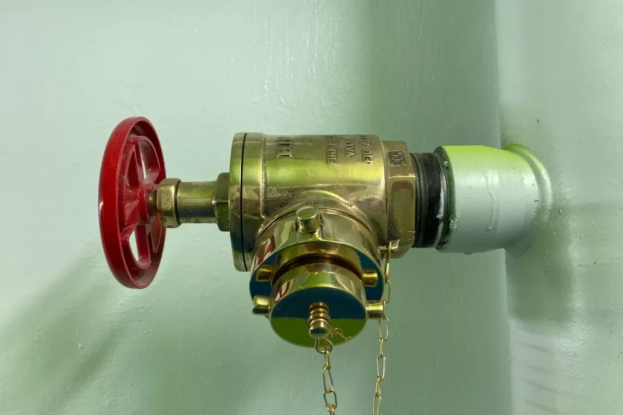 A fire-suppression system valve in a freshly painted Dana Hall stairway. (Doug Hubley/Bates College)