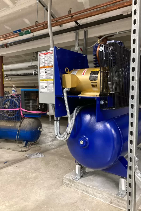 Shown in Dana Hall's attic, this shiny new contraption supplies compressed air to the labs. The dusty compressor at left was brought in temporarily for use in system testing. (Doug Hubley/Bates College)