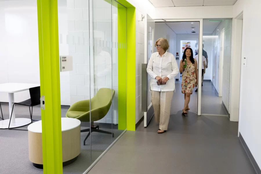 President Clayton Spencer and Hoi Ning Ngai, associate director of the Center for Purposeful Work, pass a third-floor study room during the Aug. 29 reopening reception for Dana Hall. (Phyllis Graber Jensen/Bates College)