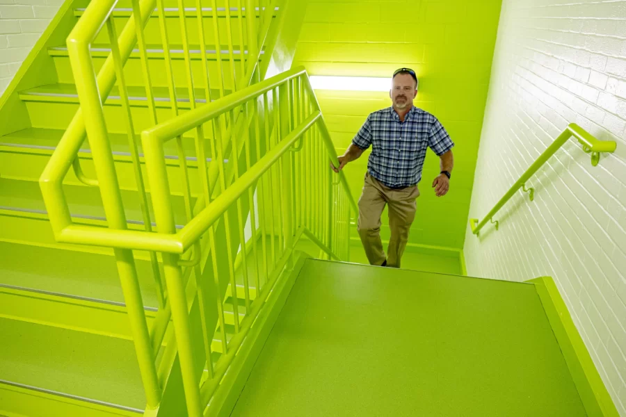 Chris Streifel, the Bates Facility Services senior project manager who has overseen the reinvention of Dana Hall and other high-profile construction projects in recent years, climbs a Dana stairway during the Aug. 29 Dana reopening. (Phyllis Graber Jensen/Bates College)