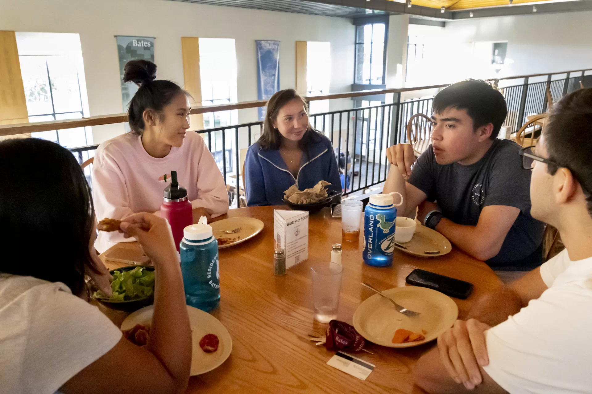 Commons at dinner hour on Thursday, Sept. 1, 2022. Students eat on and depart the messanine level of Commons. The group at the table, all res life leaders, said they chose to eat on that level for the relative quiet. Looking over Sofia Hahn’s shoulder, from left: Sofia Hahn, Nina Greeley, Lauren Farrell, David NImura, and Luke Janak.