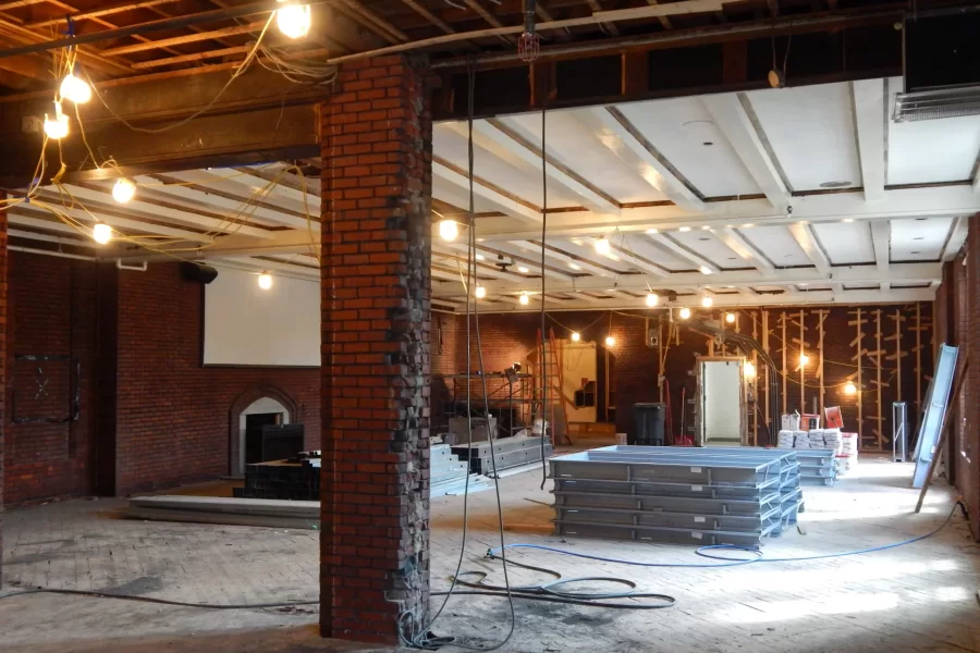 Chase Hall Lounge, minus a wall. Note the familiar fireplace at left. The yellow doorway at center shows the location of a new main stairway that will connect all levels of Chase Hall. (Doug Hubley/Bates College)